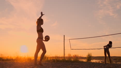 Servicio-De-Voleibol-De-Playa:-Mujer-Sirviendo-En-Un-Juego-De-Voleibol-De-Playa.-Saque-Con-Remate-Por-Encima-De-La-Cabeza.-Jóvenes-Divirtiéndose-Bajo-El-Sol-Viviendo-Un-Estilo-De-Vida-Deportivo-Activo-Y-Saludable-Al-Aire-Libre